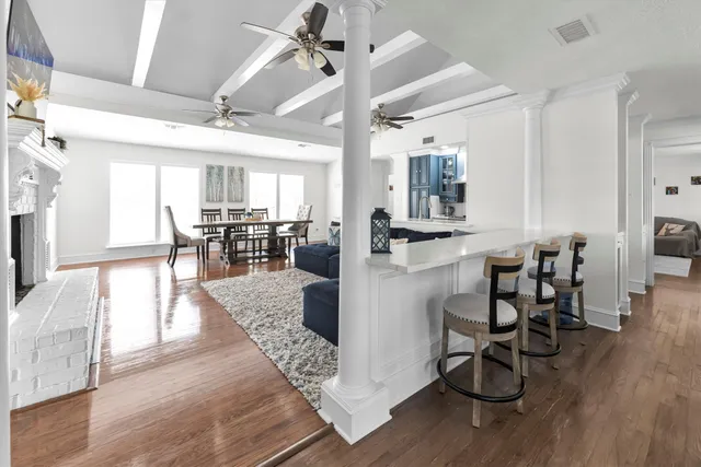 a view of a dining room and livingroom with furniture wooden floor a chandelier