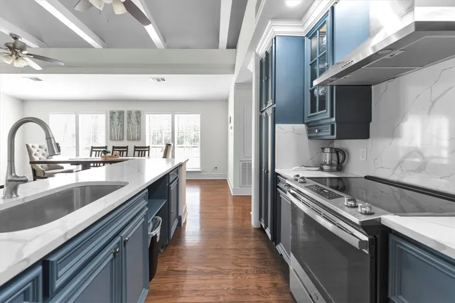 a kitchen with stainless steel appliances granite countertop a sink a stove and a refrigerator