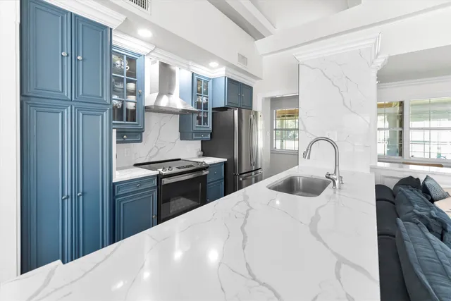 a kitchen with stainless steel appliances kitchen island a refrigerator sink and cabinets