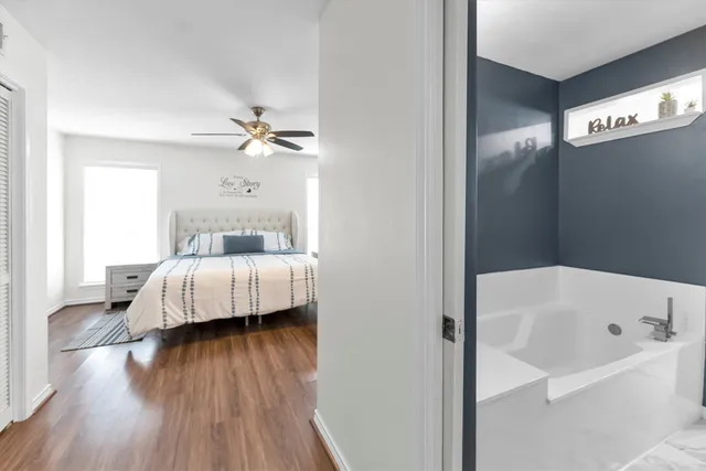 a bedroom with a bed and a window with wooden floor