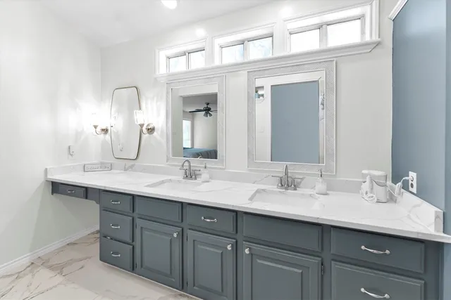 a bathroom with double sink and a mirror