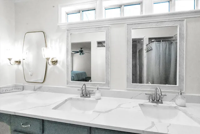 a bathroom with double vanity sinks and a mirror