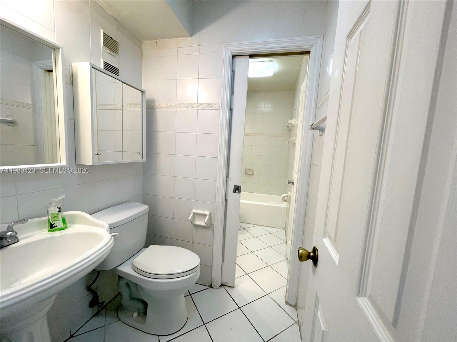 2138 Southwest 6th Street, Unit 201 Miami, FL 33135 - Photo 12 of 18 a white toilet sitting next to a bathroom sink