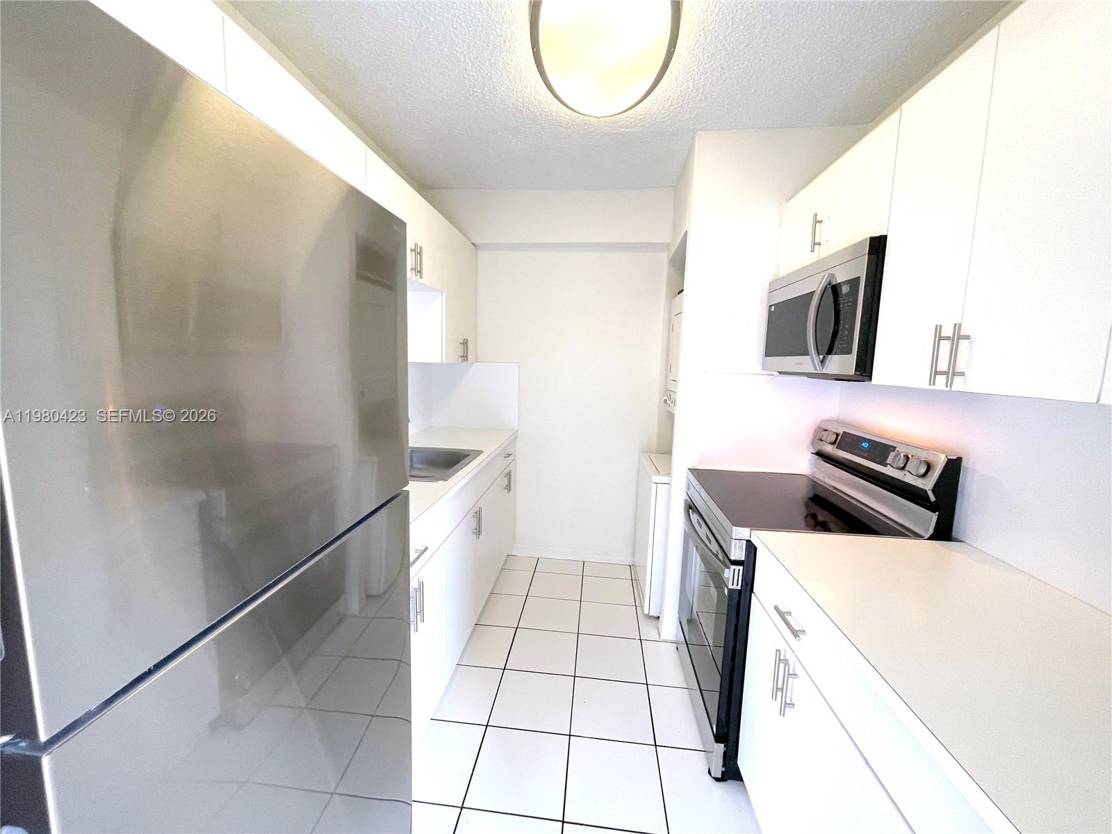 2138 Southwest 6th Street, Unit 201 Miami, FL 33135 - Photo 13 of 18 a kitchen with stainless steel appliances a stove a microwave and a refrigerator