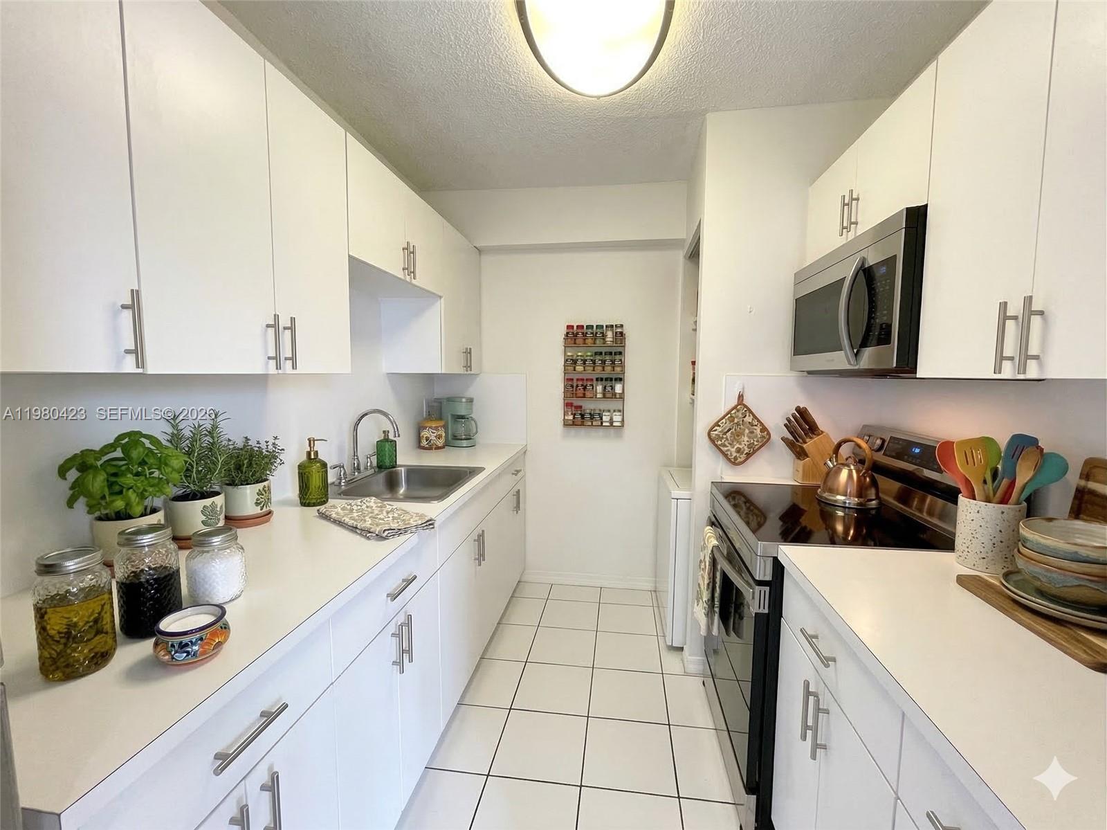 2138 Southwest 6th Street, Unit 201 Miami, FL 33135 - Photo 5 of 18 a kitchen with a sink a stove and cabinets