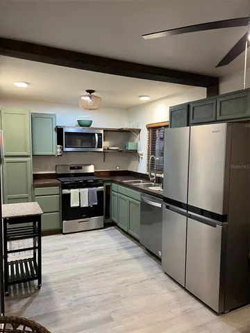 a kitchen with stainless steel appliances kitchen island granite countertop a refrigerator and a stove top oven
