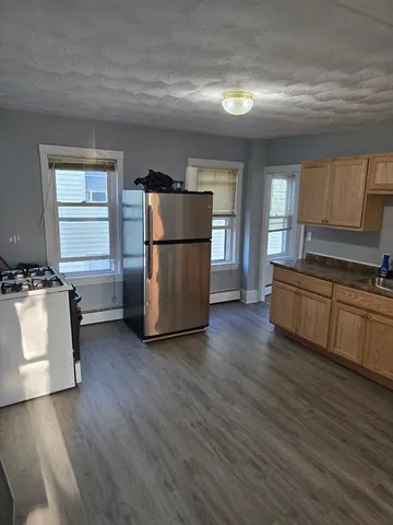 a kitchen with wooden floors and white appliances