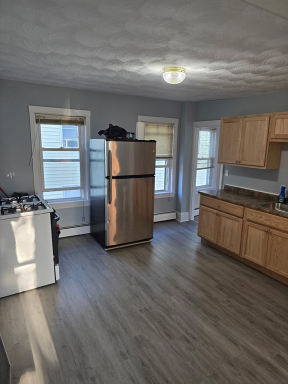 159 Warren Avenue, Unit 2 Pawtucket, RI 02860 - Photo 2 of 10 a kitchen with wooden floors and white appliances