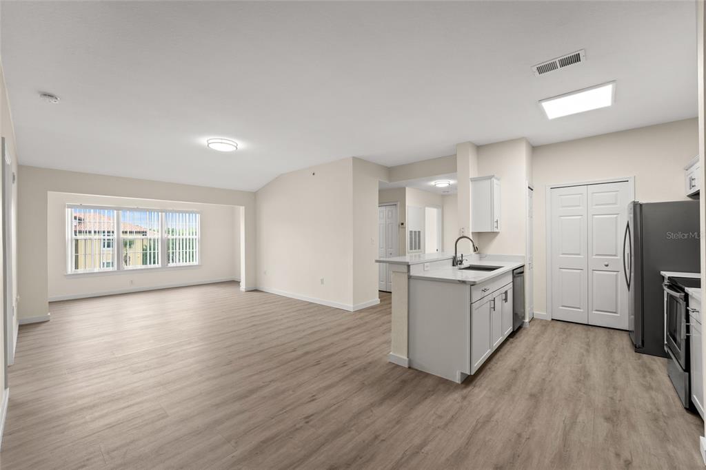 5447 Vineland Road, Unit 1308 Orlando, FL 32811 - Photo 3 of 31 a kitchen with a sink wooden floor and stainless steel appliances