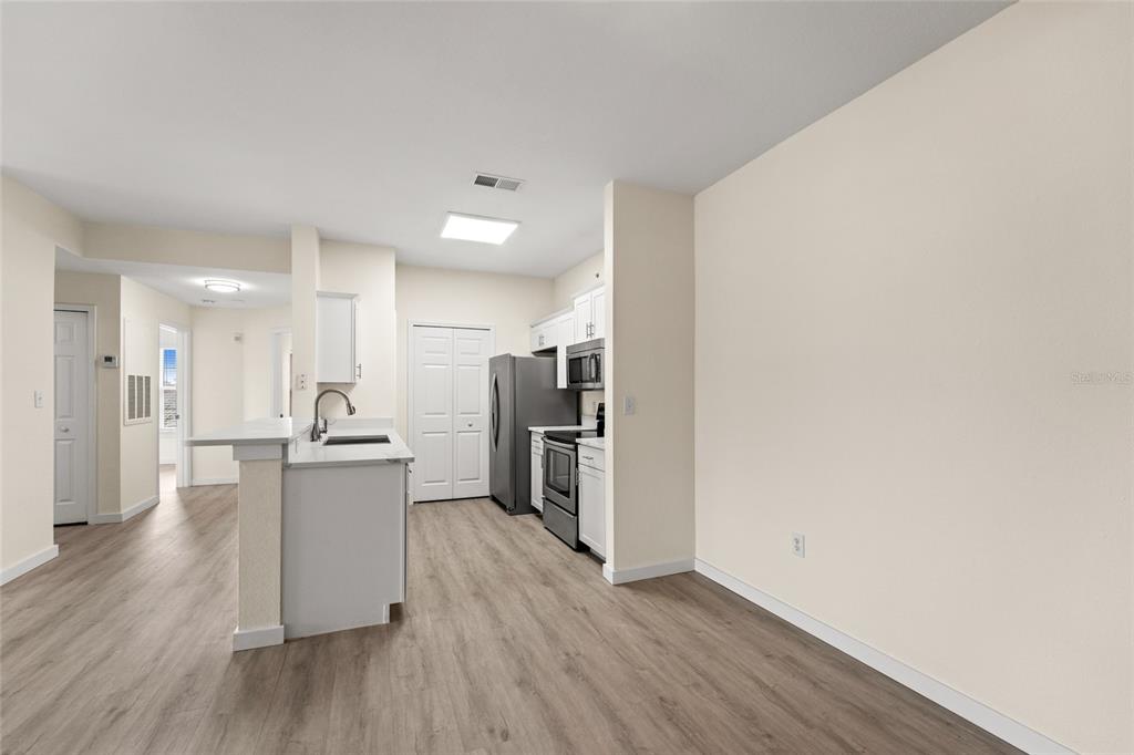 5447 Vineland Road, Unit 1308 Orlando, FL 32811 - Photo 4 of 31 a view of kitchen with refrigerator microwave and stove