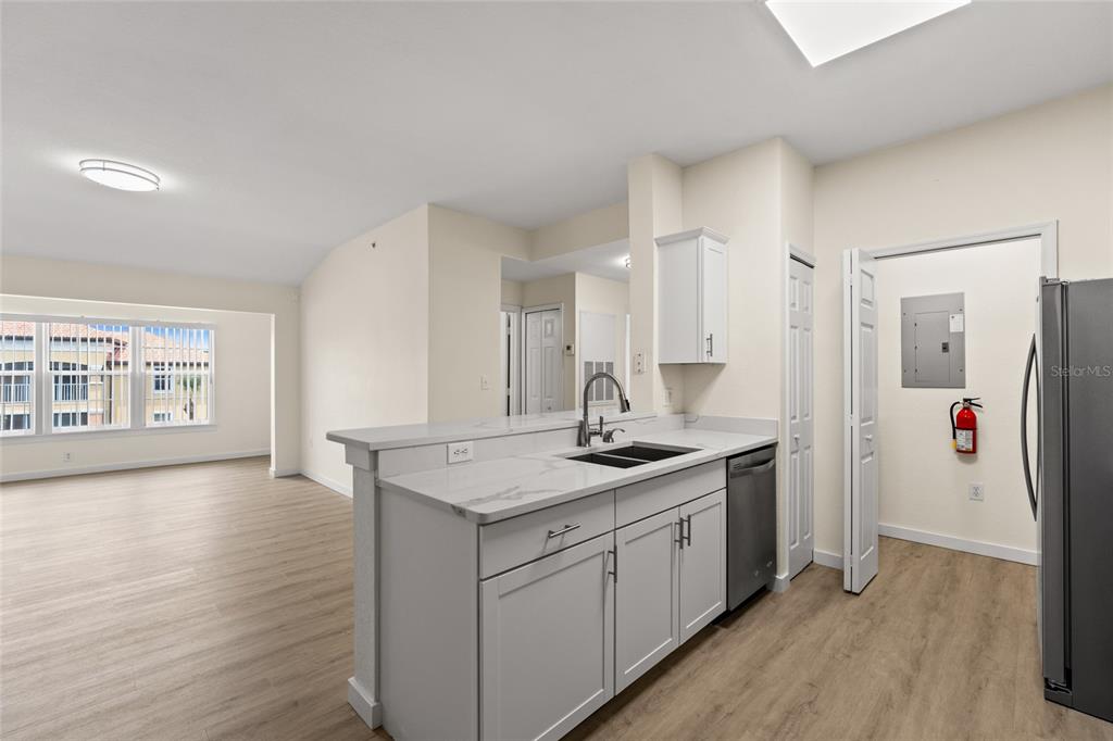 5447 Vineland Road, Unit 1308 Orlando, FL 32811 - Photo 6 of 31 a kitchen with a sink a refrigerator and wooden floor