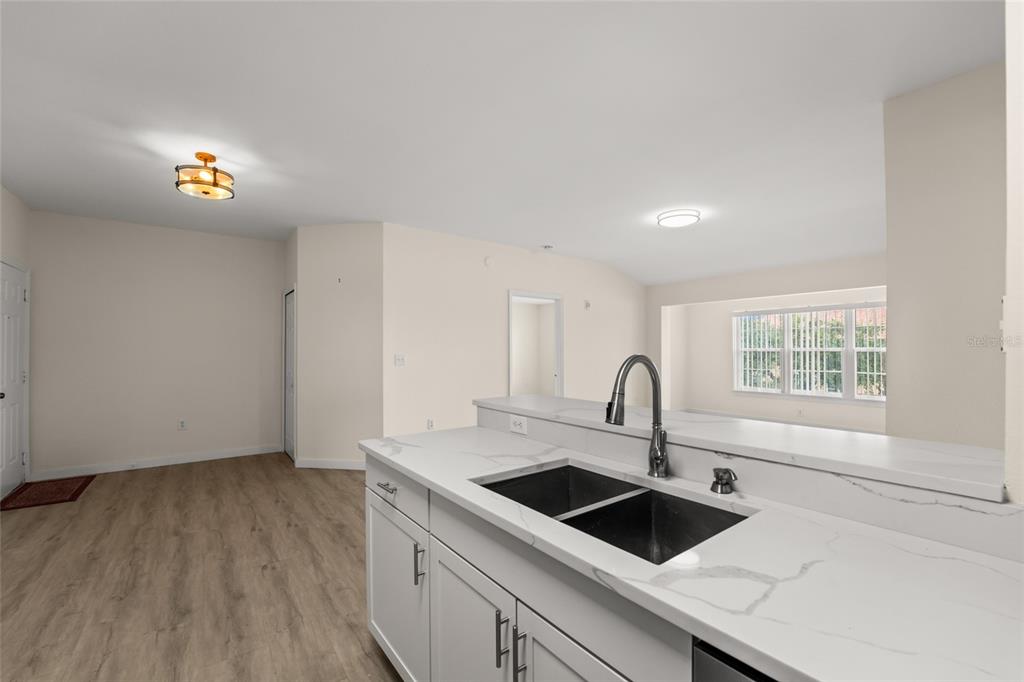 5447 Vineland Road, Unit 1308 Orlando, FL 32811 - Photo 7 of 31 a kitchen with a sink cabinets a stove and wooden floor