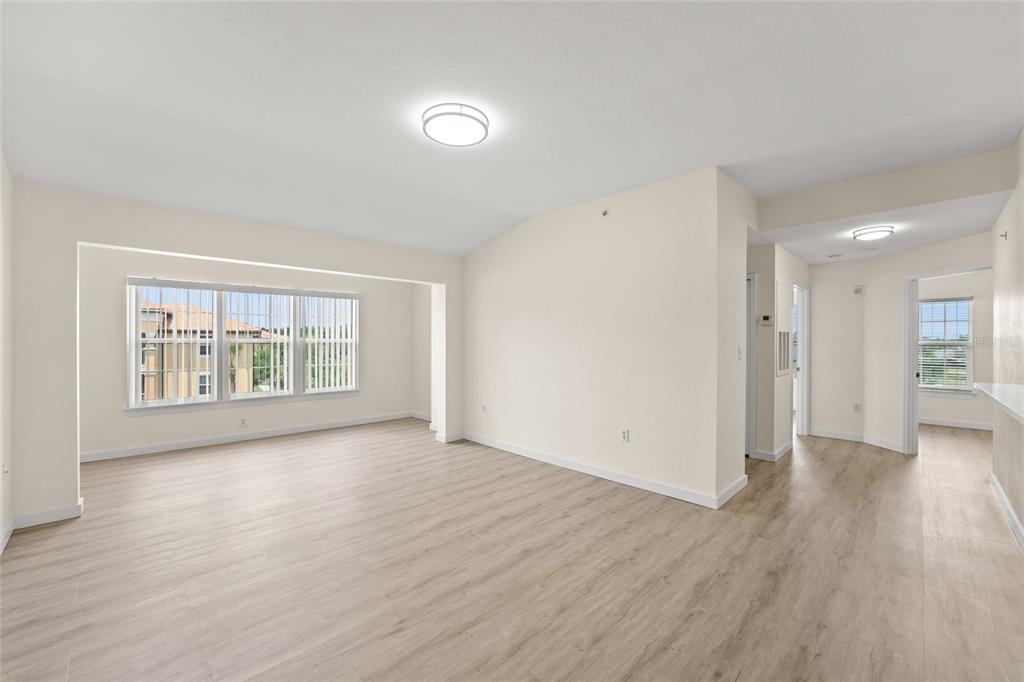 5447 Vineland Road, Unit 1308 Orlando, FL 32811 - Photo 10 of 31 an empty room with wooden floor and windows