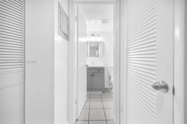 a view of a hallway with a white cabinet and a mirror