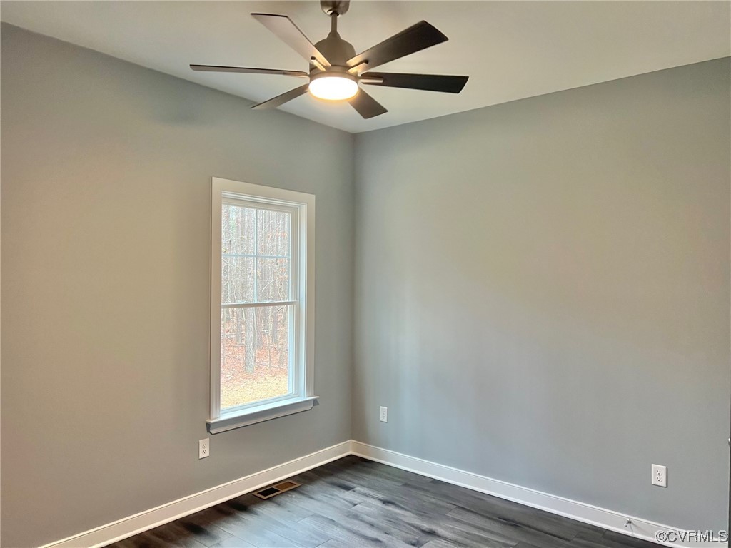 1072 Eastham Road Bumpass, VA 23024 - Photo 17 of 26 an empty room with wooden floor ceiling fan and windows
