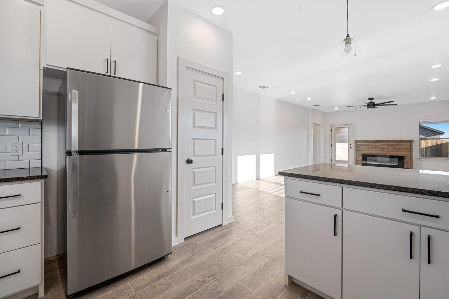 5902 Grinnell Street Lubbock, TX 79416 - Photo 11 of 26 a kitchen with granite countertop a refrigerator and a sink