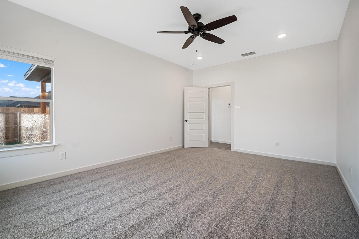5902 Grinnell Street Lubbock, TX 79416 - Photo 14 of 26 an empty room with wooden floor and windows