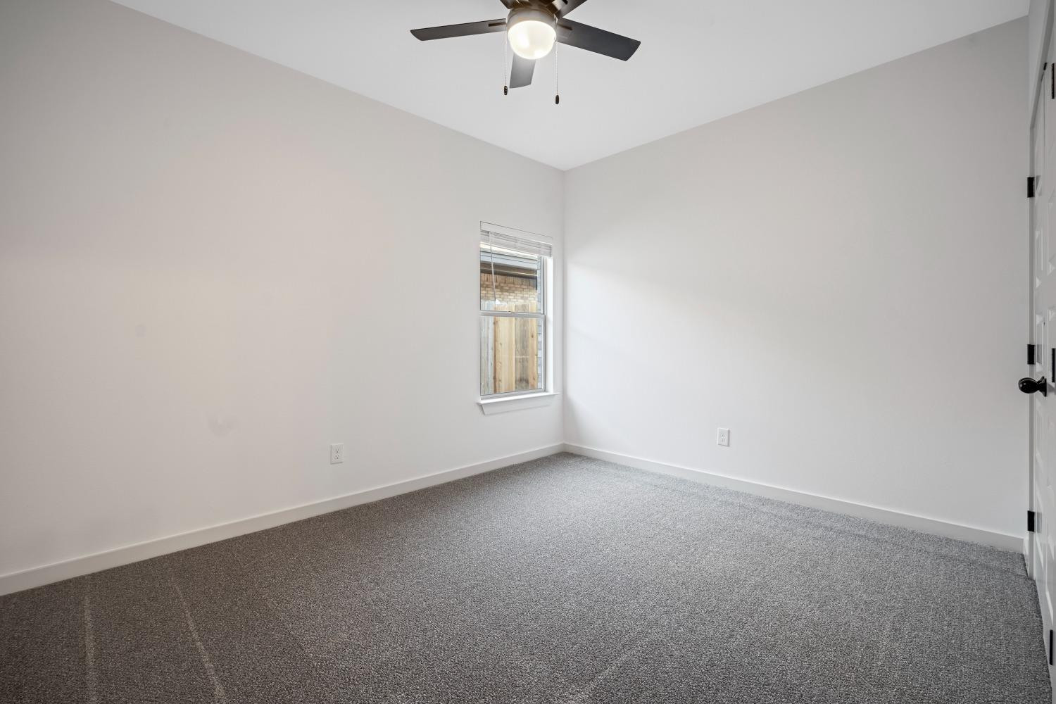 5902 Grinnell Street Lubbock, TX 79416 - Photo 21 of 26 an empty room with a chandelier fan and windows