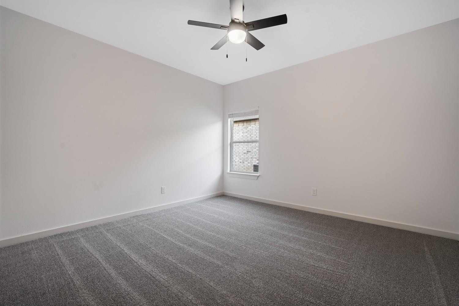 5902 Grinnell Street Lubbock, TX 79416 - Photo 23 of 26 an empty room with a ceiling fan and a window