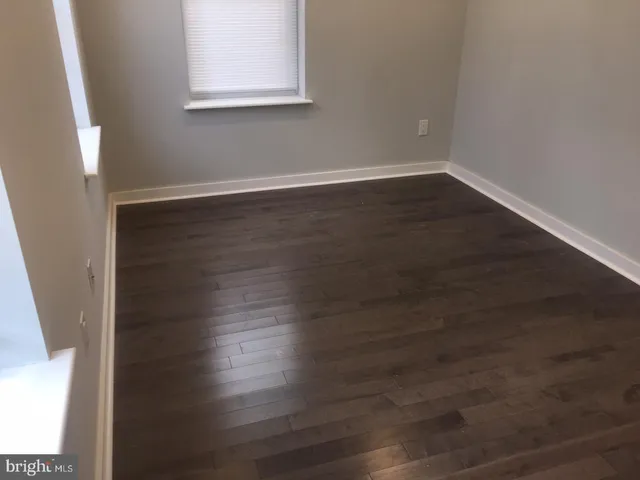 a room with wooden floor and window