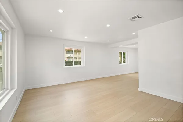 a large kitchen with a large counter top a sink stainless steel appliances and cabinets
