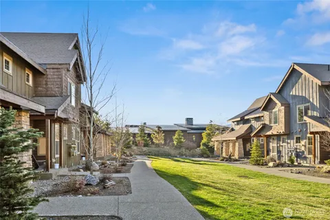 a view of a big house with pool and chairs