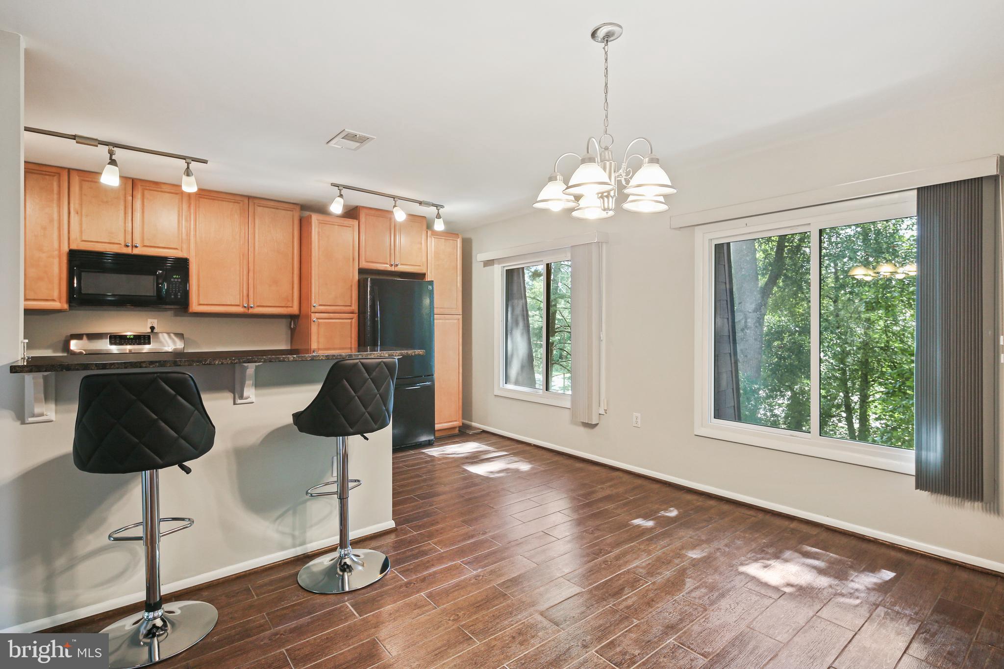 5239 West Running Brook Road, Unit 301 Columbia, MD 21044 - Photo 13 of 33 a kitchen with dining table and chairs