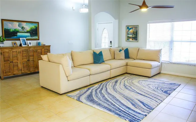 a living room with furniture a flat screen tv and a large window