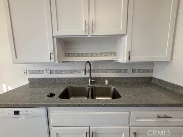 a kitchen with granite countertop a sink and cabinets
