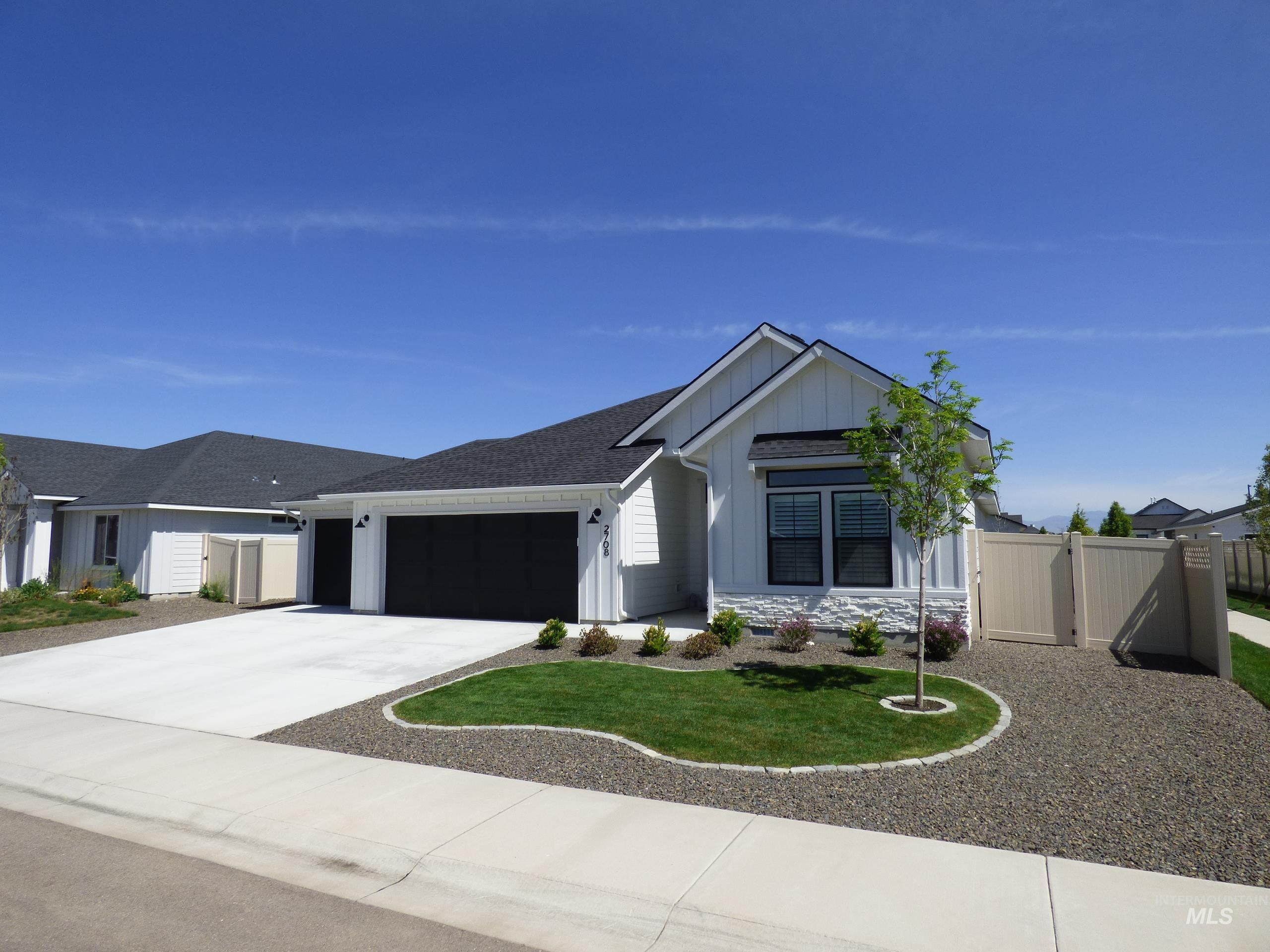 2708 East Buckaroo Drive Kuna, ID 83634 - Photo 2 of 48 Modern farmhouse exterior featuring white vertical siding and dark-trimmed windows