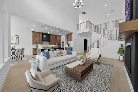a living room with furniture kitchen view and a chandelier