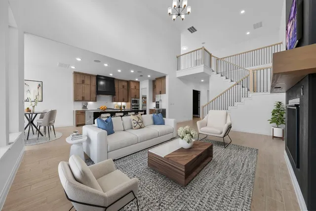 a living room with furniture kitchen view and a chandelier