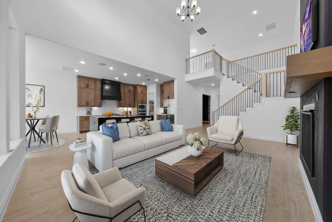 a living room with furniture kitchen view and a chandelier