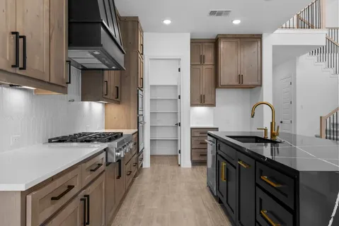 a kitchen with kitchen island granite countertop wooden cabinets and a sink