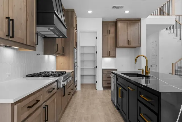 a kitchen with kitchen island granite countertop wooden cabinets and a sink