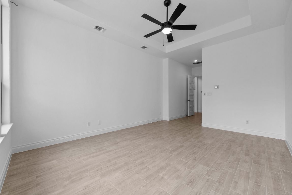 109 Strawberry Lane Georgetown, TX 78628 - Photo 27 of 40 an empty room with a ceiling fan and wooden floor