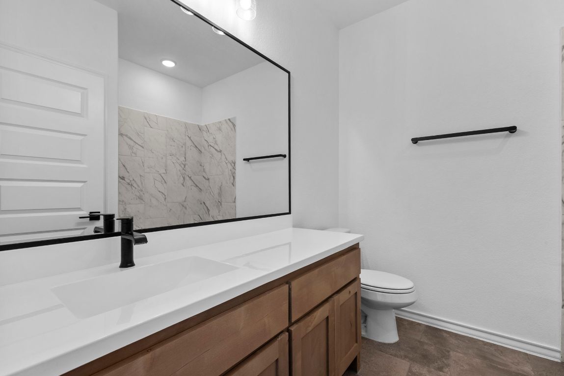 109 Strawberry Lane Georgetown, TX 78628 - Photo 32 of 40 a bathroom with a toilet sink and mirror