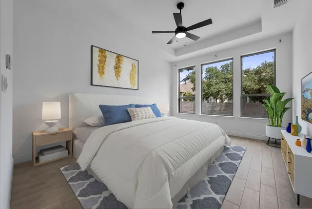 a spacious bedroom with a bed a window and a chandelier
