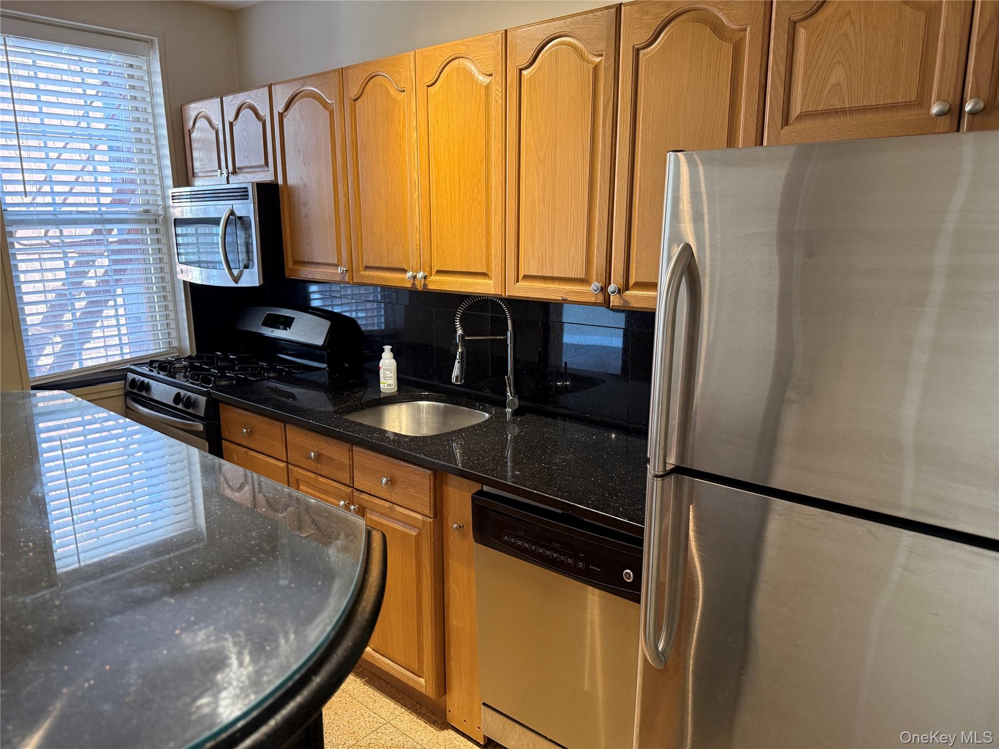 796 Bronx River Road, Unit B38 Bronxville, NY 10708 - Photo 7 of 31 a kitchen with stainless steel appliances granite countertop a refrigerator and a stove