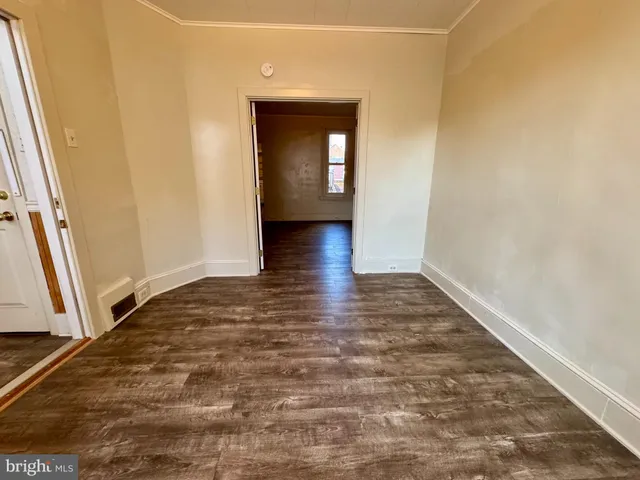a view of a hallway with wooden floor and stairs