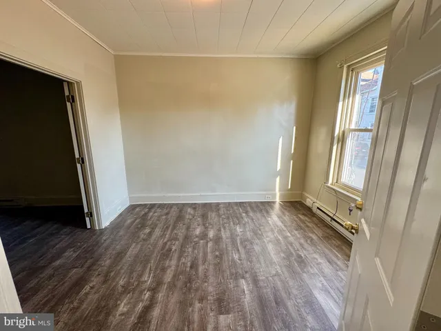 a view of a room with wooden floor and a window
