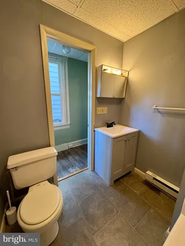 a bathroom with a toilet a sink and mirror