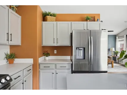 a kitchen with stainless steel appliances white cabinets and a refrigerator