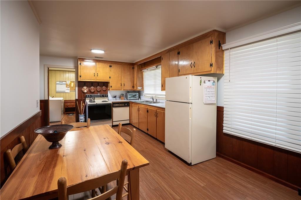 67 Dixie Park Drive Northwest Rome, GA 30165 - Photo 9 of 27 a kitchen with a refrigerator a stove top oven a sink dishwasher and white cabinets with wooden floor