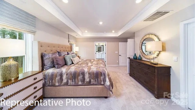 a spacious bedroom with a bed and a flat screen tv