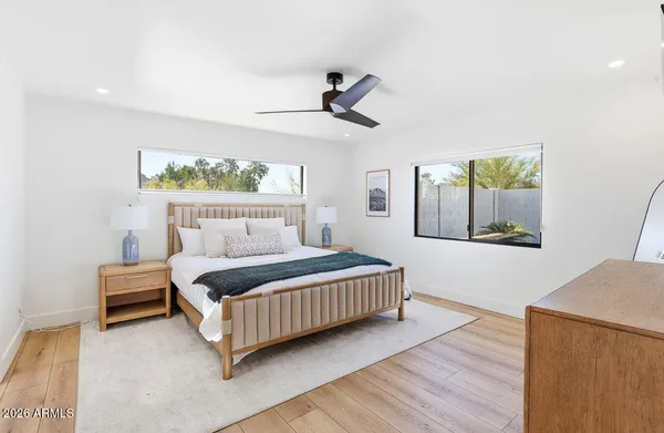 a bedroom with a bed lamp and a large window