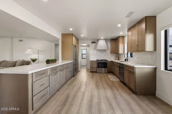 a large kitchen with stainless steel appliances sink a microwave and cabinets