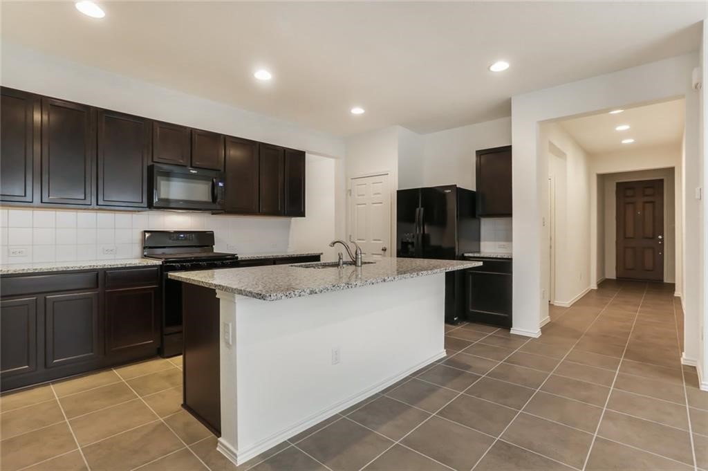 2233 Ringstaff Road Leander, TX 78641 - Photo 3 of 18 a kitchen with stainless steel appliances granite countertop a sink stove and refrigerator
