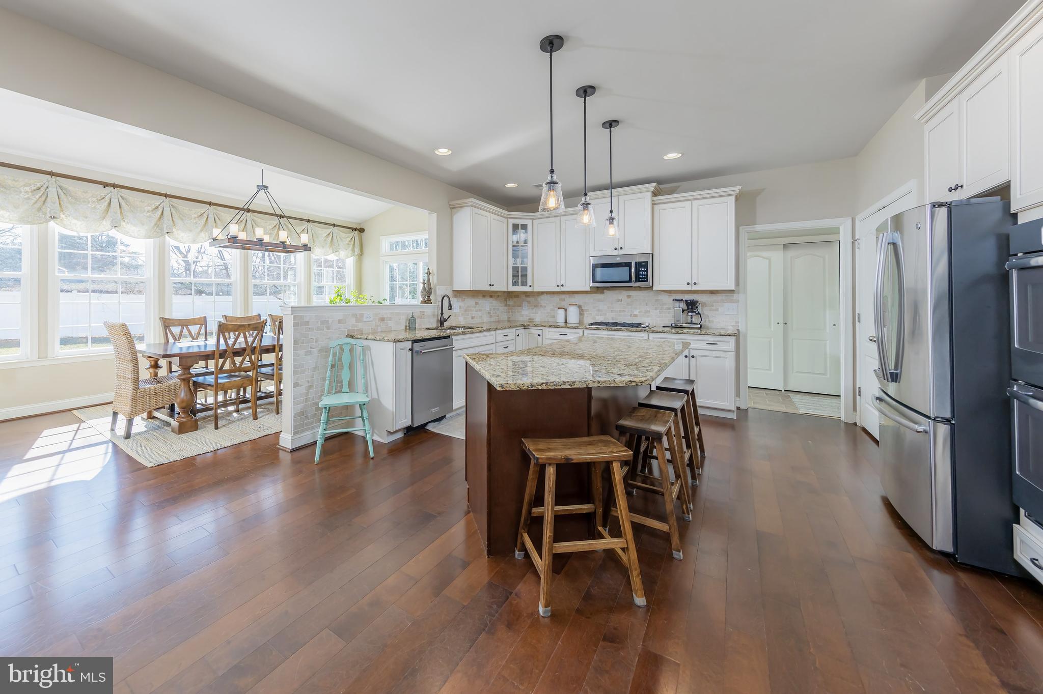 112 Robert Botto Way Clarksboro, NJ 08020 - Photo 6 of 60 a kitchen with stainless steel appliances kitchen island wooden floors refrigerator dining table and chairs