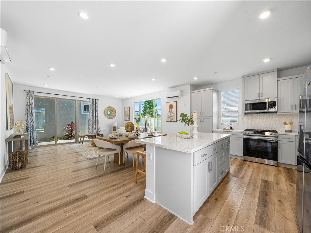 191 Lynx Irvine, CA 92618 - Photo 4 of 26 a view of a kitchen with kitchen island a sink wooden floor and counter top space
